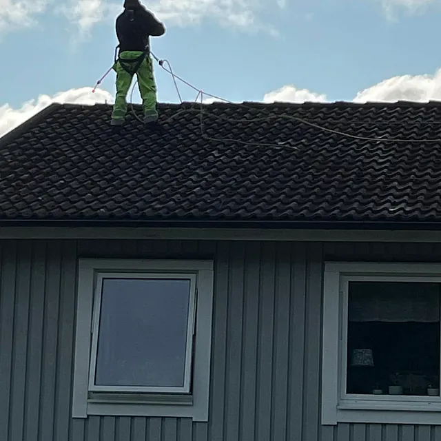 man står på taket och tvättar taket
